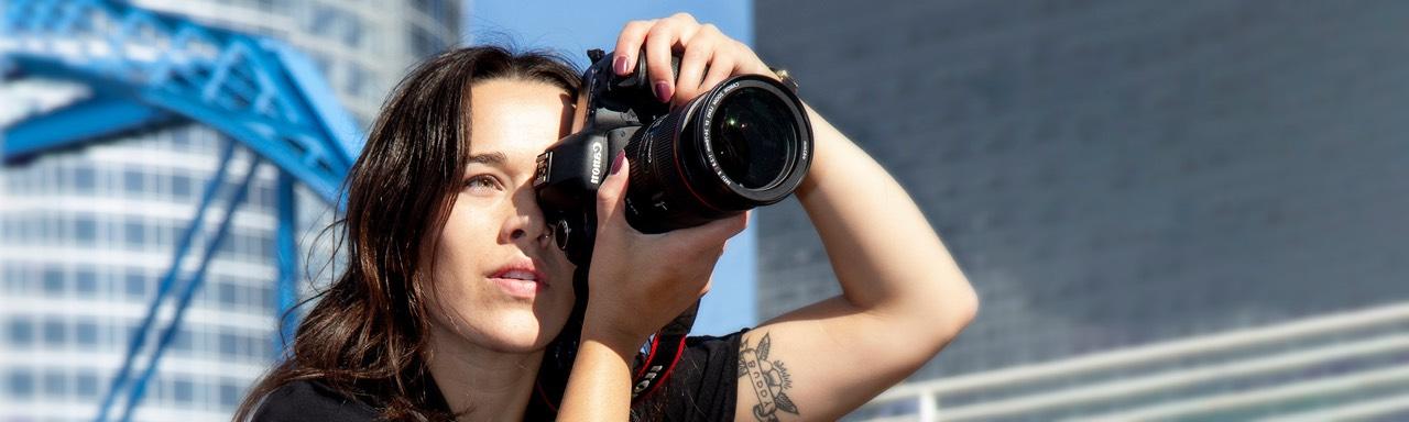 A young woman photographing with dark hair